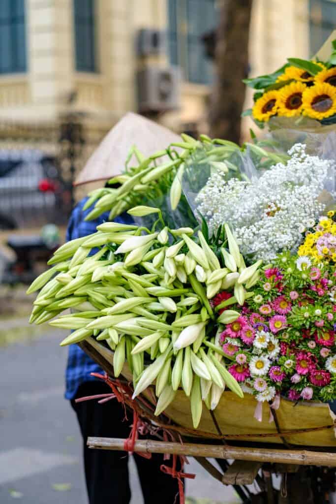 A woman is selling flowers on a cart in Vietnam